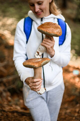 young handsome woman gently holding two large mushrooms in her hands