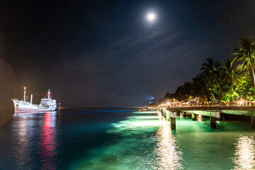 Nacht auf den Malediven mit großem beleuchteten Schiff
