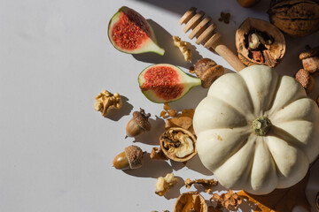 Autumn still-life with white pumpkin, sliced figs and walnuts isolated on white. Top view. Healthy eating concept.