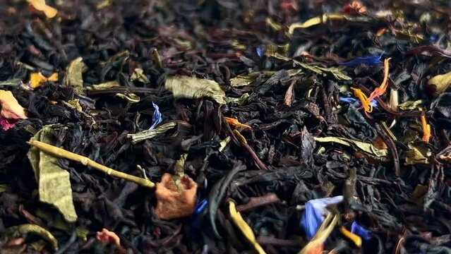 Falling dried black tea leaves. Close-up. 