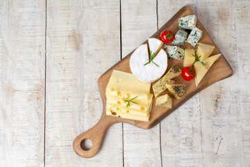 Assortment of different cheese types on wooden board. Different types of delicious cheese, closeup. Copy space. Cheese Collection. Top view copy space for text or logo
