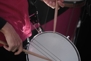 Close up on percussions of a street orchestra. The musicians are wearing pink costumes. The...