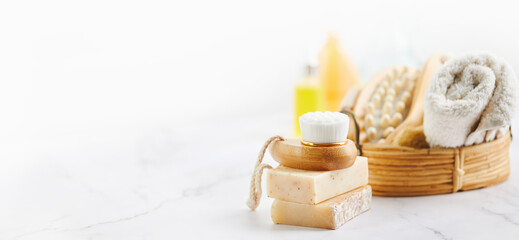 Two bars of soap, wash and massage brushes, and rolled towel. Hygienic bathroom and spa accessories.