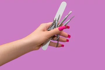  Female hand with pink nail design. Mate pink nail polish manicure. Female model hand hold manicure tools. © devmarya