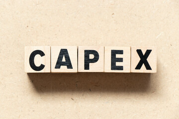 Alphabet letter block in word CAPEX (Abbreviation of Capital Expenditure) on wood background