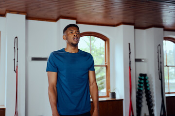 Determined young black man in sportswear taking a breather at the gym