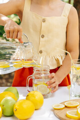 girl pouring homemade lemonade into a glass at a lemonade party