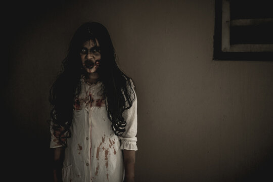 Woman in ghost or zombie on halloween festival at dark place, threatening and wants to attack you. Horror or halloween festival concept.