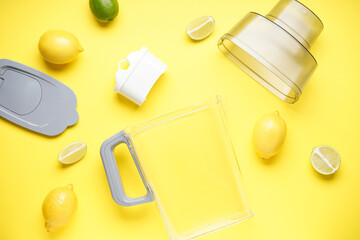 Water filter jug with lemon on a yellow background, top view.