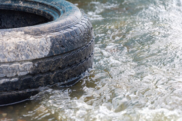 Old car tire polluting the environment and sea. 