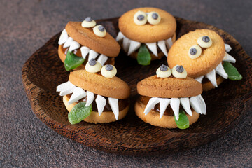 Halloween Party Treats - Cookie Monsters with Marshmallows, Condensed milk and Chocolate on wooden...