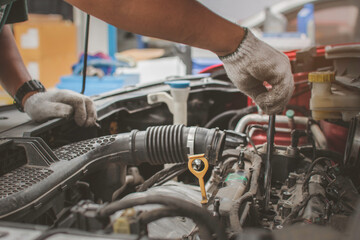 Mechanic's hands use a wrench to fix the engine. The concept of a car repair center provides maintenance, maintenance and car maintenance services.