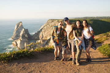 Happy family of backpackers posing at landscape. Parents with teen daughters and son hiking in...