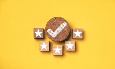 Correct sign mark withe five stars to round wooden on yellow background for best quality assurance guarantee product certificate and ISO service standardization concept.