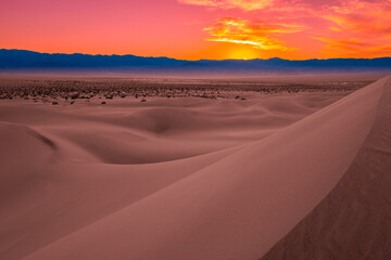Mesquite Flat Sand Dunes and abstract geometry of curving arid desert terrain at pink sunset in Death Valley National Park, California