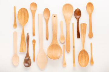 set of empty wooden spoons of different sizes with over white background, trendy flat lay