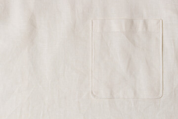 Fototapeta na wymiar Pocket on natural white linen blouse fabric background. Top view