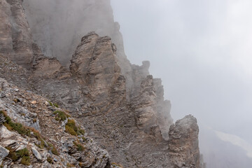 Rock formations on mystical foggy hiking trail leading to Mount Olympus (Mytikas, Skala, Stefani),...