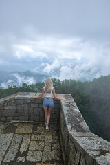 Girl at the top of the tower admires the view of the mountains