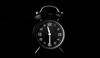 Time concept. black alarm clock in dark background with copy space.
