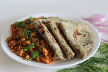 Dil Paratha served with scrambles cottage cheese and garnished with coriander leaves.