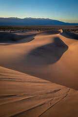 Mesquite Flat Sand Dunes and abstract geometry of curving arid desert terrain at sunset in Death Valley National Park, California