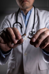 タバコを折って禁煙をすすめる男性の医師