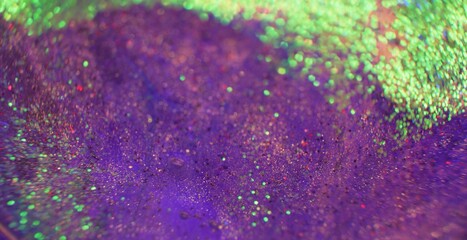 Bokeh light background. Glitter texture. Firework sparks. Defocused neon purple green color shimmering circles on bright grain surface.
