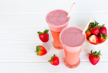 Strawberry yogurt fruit juice smoothie pink colorful fruit juice milkshake blend beverage healthy high protein the taste yummy In glass drink episode morning on white wood background.
