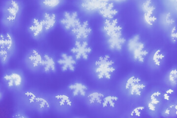 Bokeh as lights white snowflakes on blue purple background, abstract winter holiday wallpaper with blurred pattern. Christmas or New Year abstract image as backdrop, aesthetic blur background