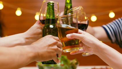 Group of happy young Asian people with friends celebrating clinking glasses during dinner party