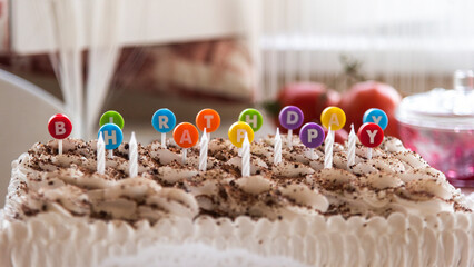 birthday cake with letter multicolored inserts, meaning a happy birthday