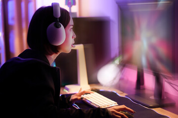Young Asian Pretty Pro Gamer win in Online Video Game. young playing game online at home. Gamer controlling joystick for video game. Teenage girls leisure game in neon light room at home © Montri