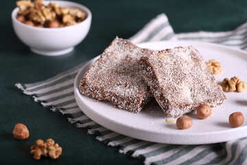 brownie cake with coconut and nuts. chocolate dessert with coconut. a piece of chocolate cake with coconut chips.
