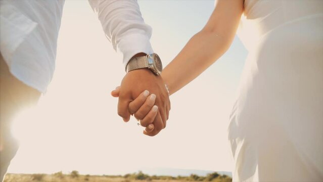 Hands at sunset. Holding hands together. love