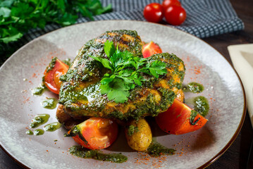Grilled heart-shaped chicken breast with fresh tomatoes and chimichurri sauce.