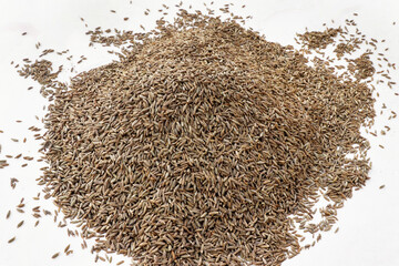 Heap of cumin seeds isolated on white background