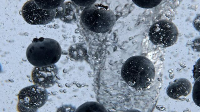 Mineral water blueberries tornado closeup. Organic berries spinning cold water
