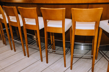 Fototapeta na wymiar Wooden vintage chairs stand in a row indoors.