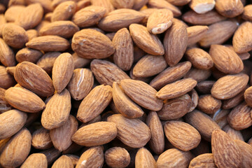 Fototapeta premium fresh peeled raw almonds ready for sale on counter, background