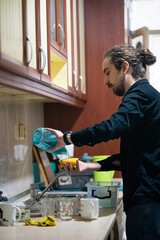 man washing dishes in the kitchen