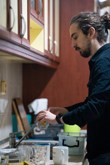 man washing dishes in the kitchen