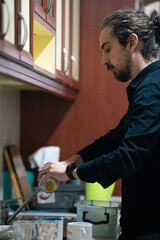 man washing dishes in the kitchen