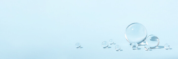 Blue background with transparent glass balls. Minimal concept and soft sunlight.