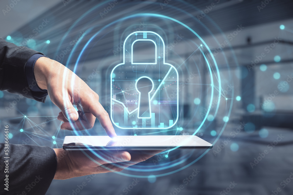 Poster close up of businessman hand pointing at tablet with abstract glowing padlock hologram on blurry off