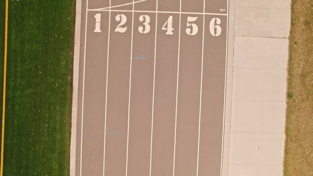 Sportsman or athlete runner person view of running in a competition. POV of running tracks and race tracks with white paint markers. Running on running track.