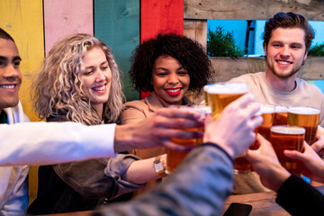 Friends drinking and toasting with beer at pub
