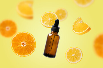 Citrus fruits and dark glass cosmetic bottle falling in the air. Beauty serum with lemons and oranges isolated on yellow background. Cosmetic oil, vitamin C concept