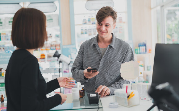 A male customer asks a pharmacist for a prescription pill.Female pharmacist with medical expertise.he doctor prescribes the pills according to the customer  prescription.