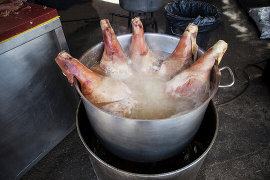 5 legs of ham cooking in a giant pot